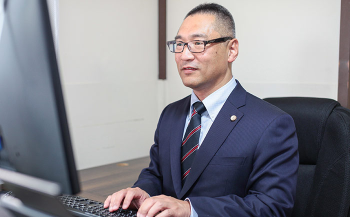 法律文書を作成する別府弁護士